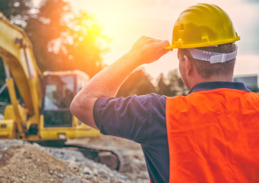 A construction professional holding his hard hat.